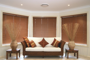 White couch in the living room with red Timberstyle Venetian blinds in the windows